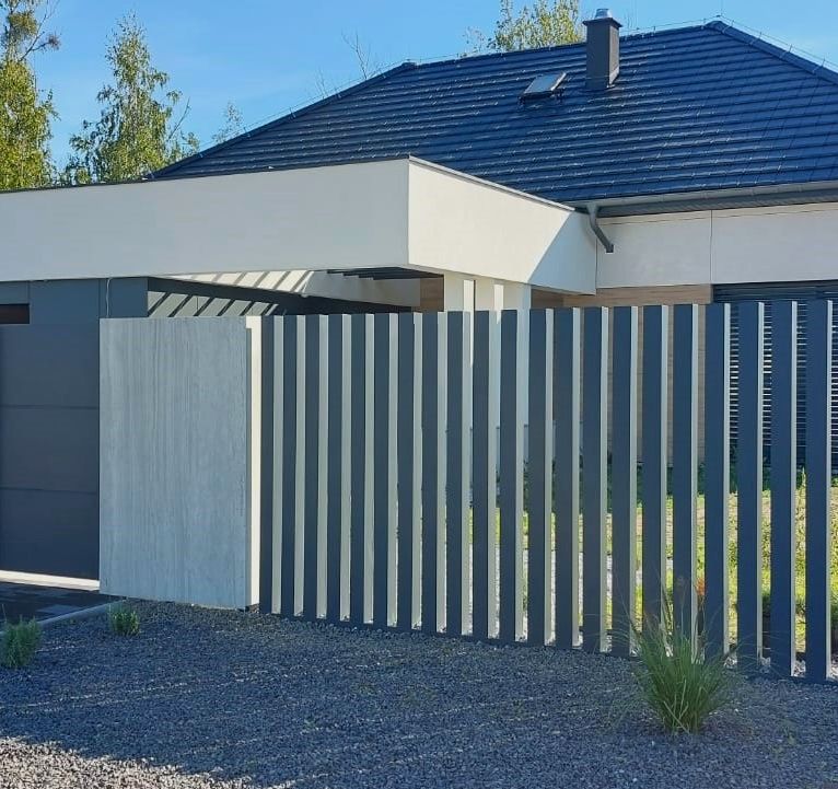 Ogrodzenie aluminiowe model Prestige - pionowe przęsła z furtką na tle nowoczesnego parterowego domu HomeKoncept.